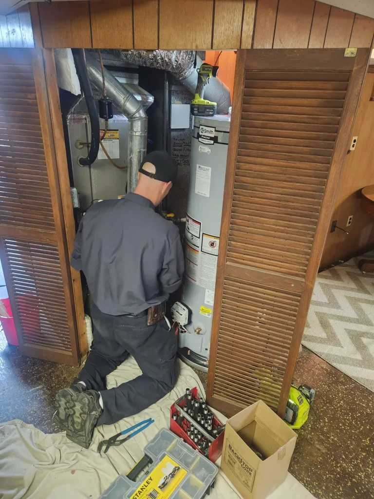 Metcalf Plumbing technician working in the closet to install a new water heater