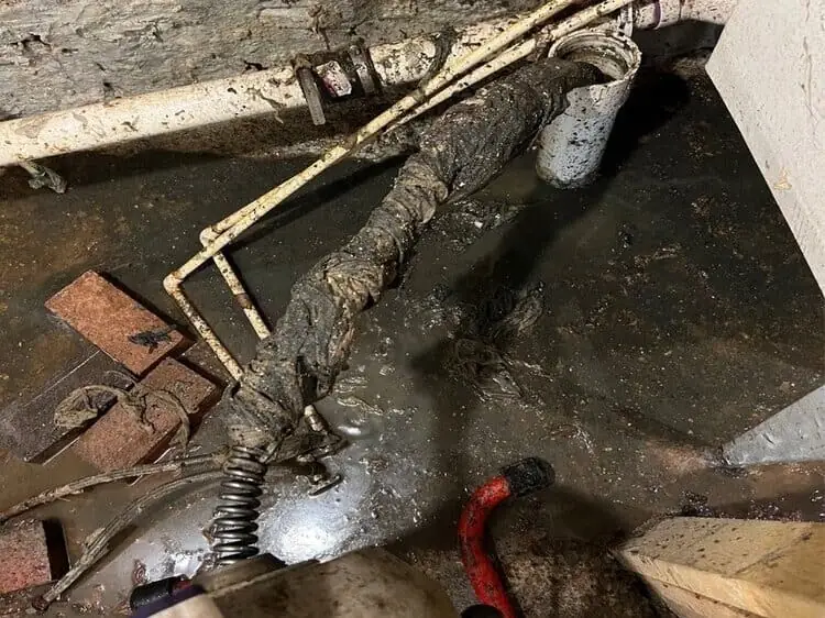 Metcalf technician clearing a clogged basement drain line