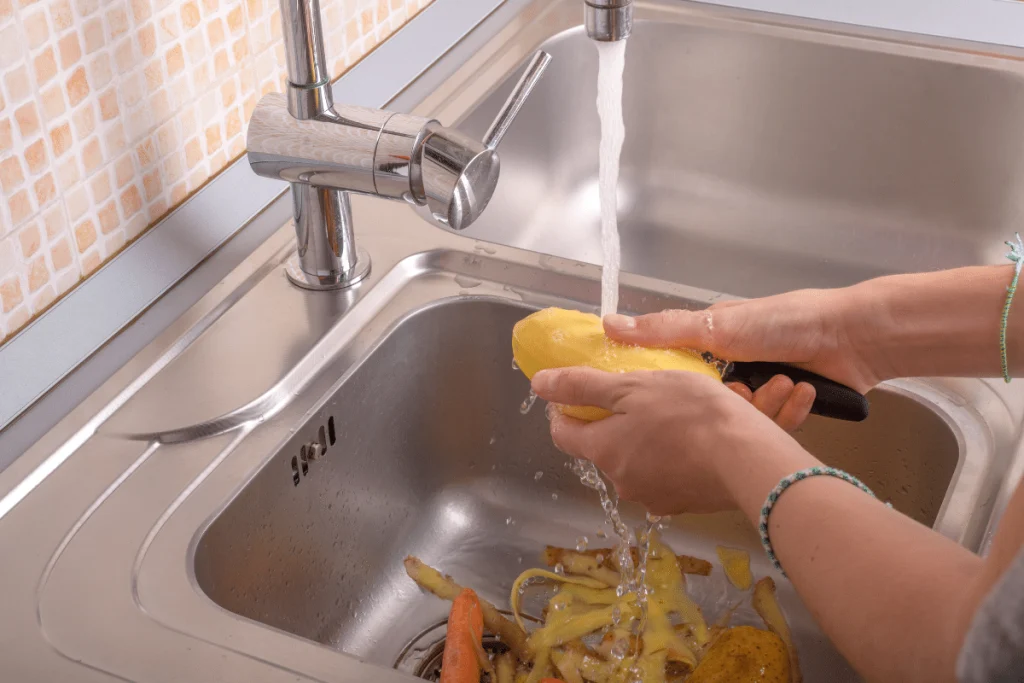Kitchen sink filled with food waste that leads to a blocked drain line